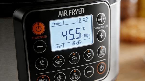 A close-up of an air fryer's digital control panel showing capacity and wattage specifications.