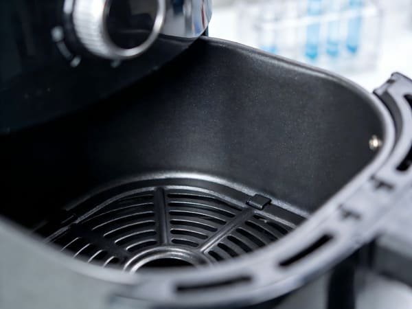 An air fryer basket with a focus on its non-stick coating material.